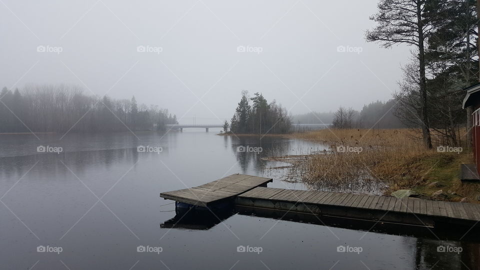 Wooden pier over lake in foggy weather