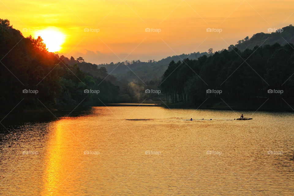 Beauty while the sunset in the midst of nature, there is a lake for people to swim and relax together.