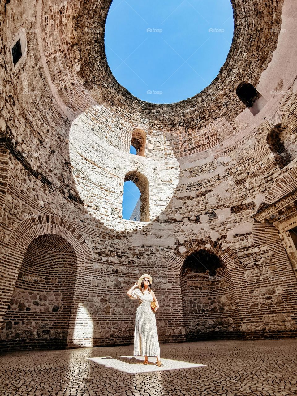 Young woman standing in amazing round ancient building called Vestibule inside Diocletian's palace in Split, Croatia