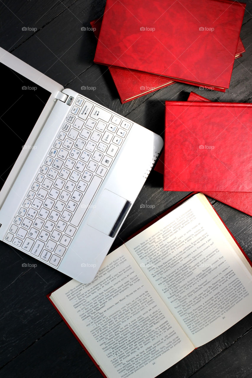 Laptop and red books on a gray background