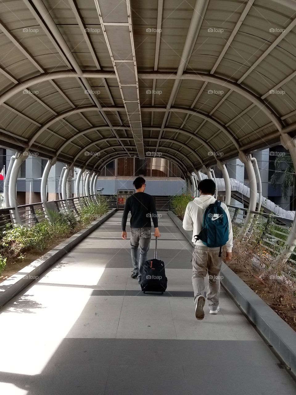 men walking in a footbridge with canopy