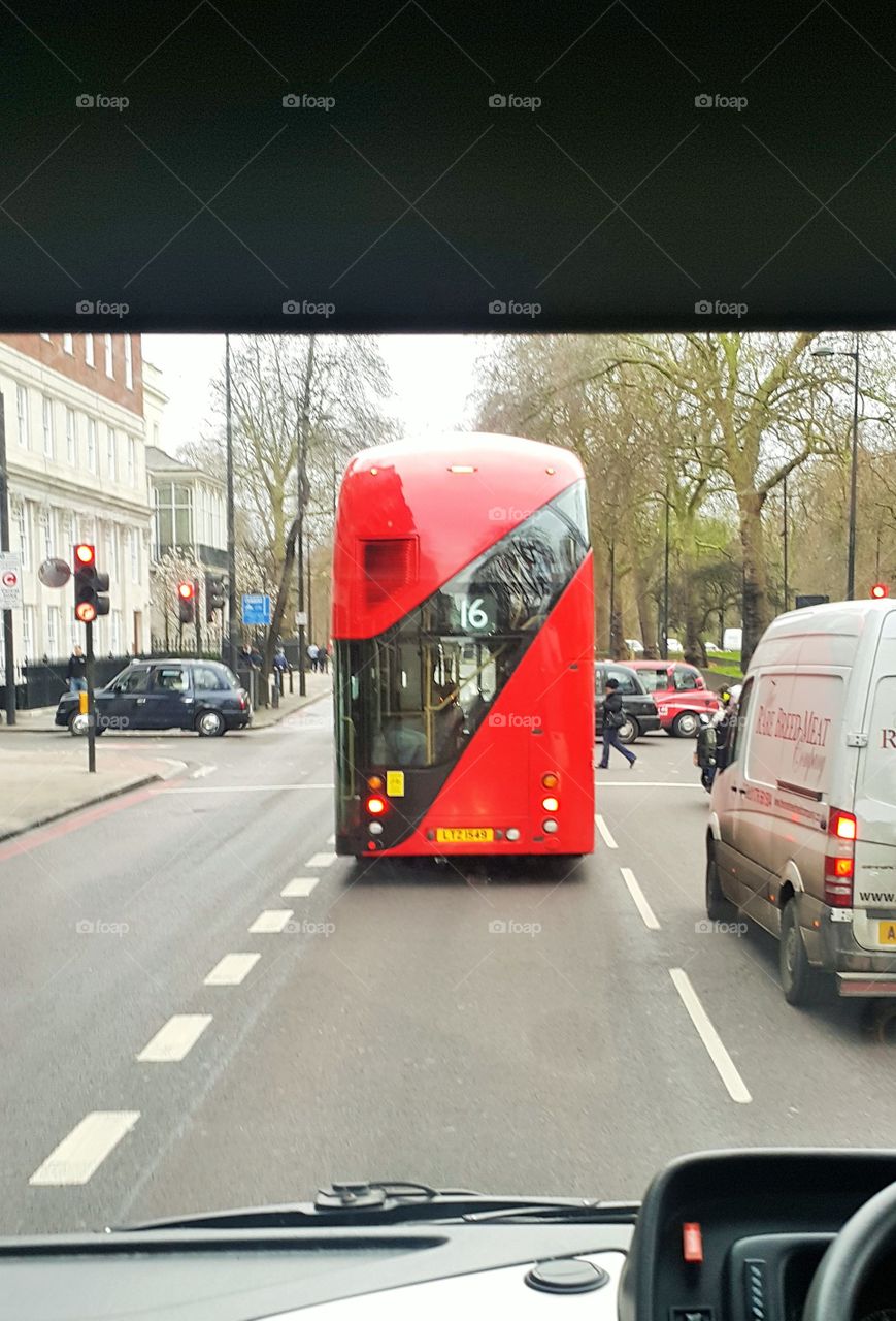 LONDON RED BUS GUIDED BY ROAD MARKINGS.  
Composition - guiding lines and a touch of red. Subtle background.