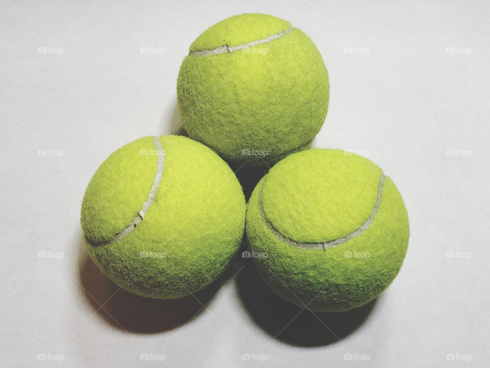 Three tennis balls in a white background