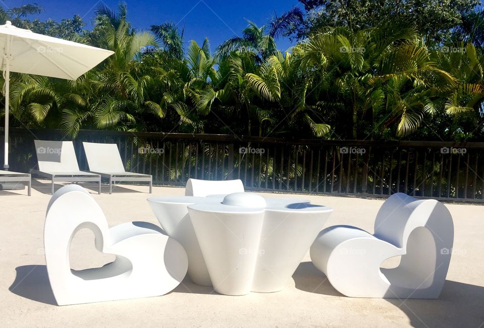 Garden furniture, cute heart seats and table by the swimming pool