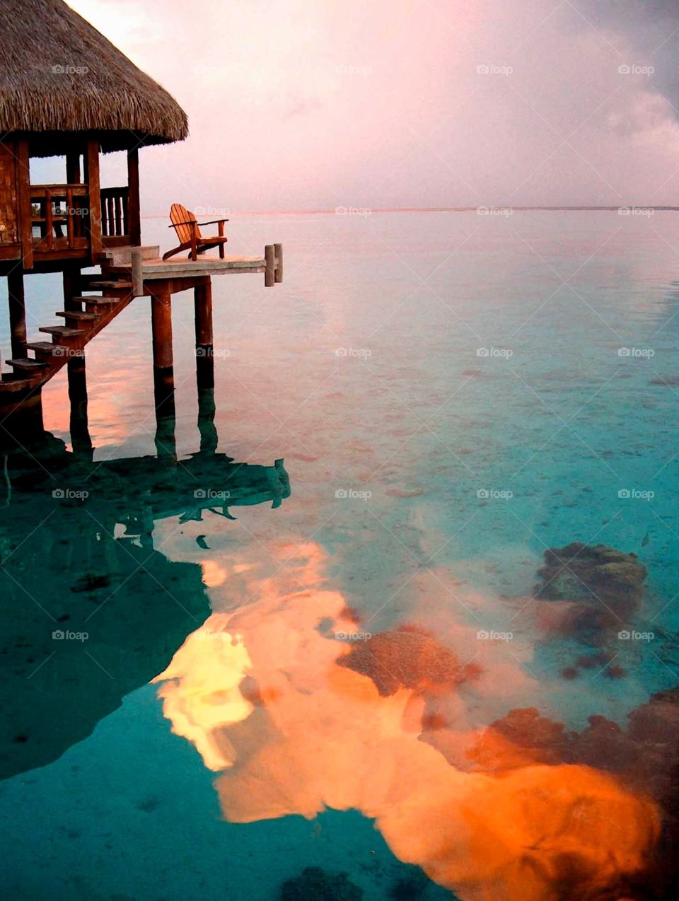 Bungalow in Moorea. The clouds over the island were lit by the setting sun and reflected in the pristine lagoon of Moorea, French Polynesia.