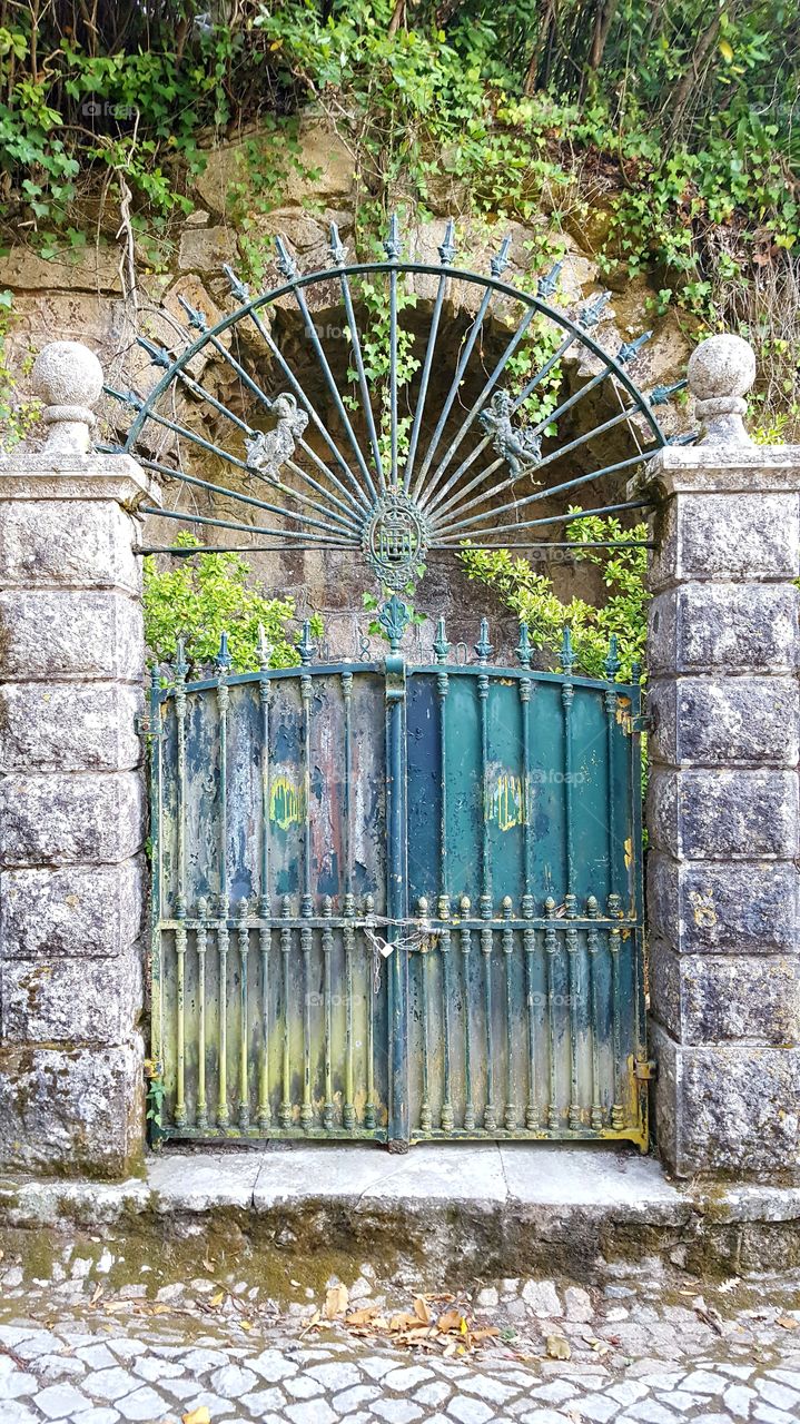 An old gate and its beautiful coat of arms, lost in middle of Sintra's Mountain, Portugal.