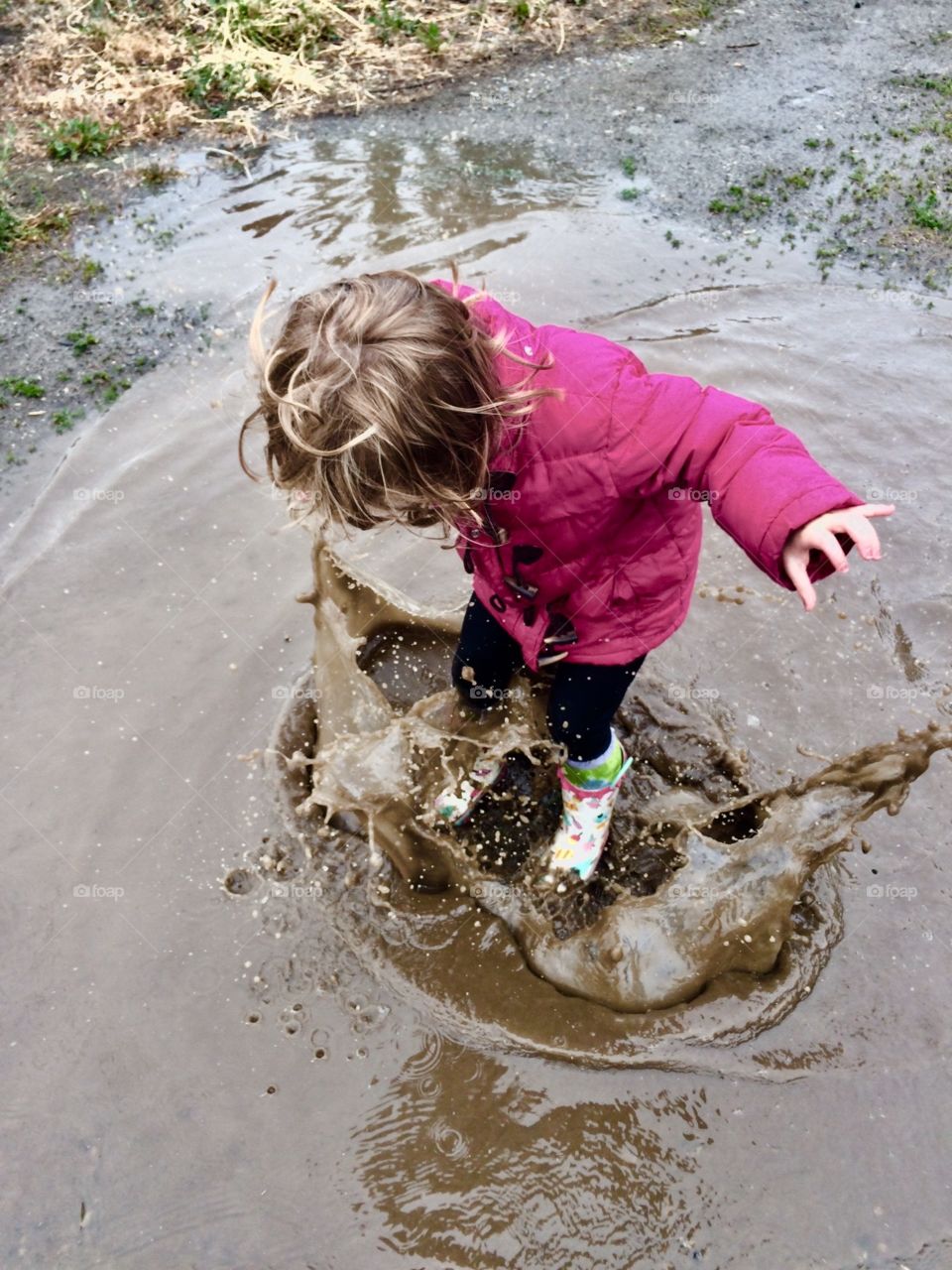 Child jumping in puddles