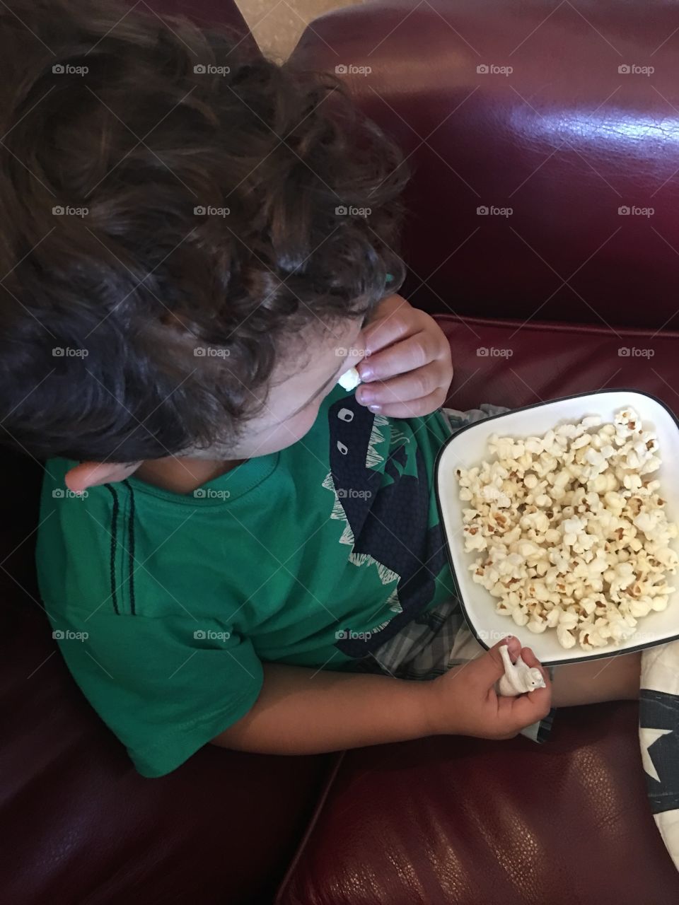Boy eating popcorn.