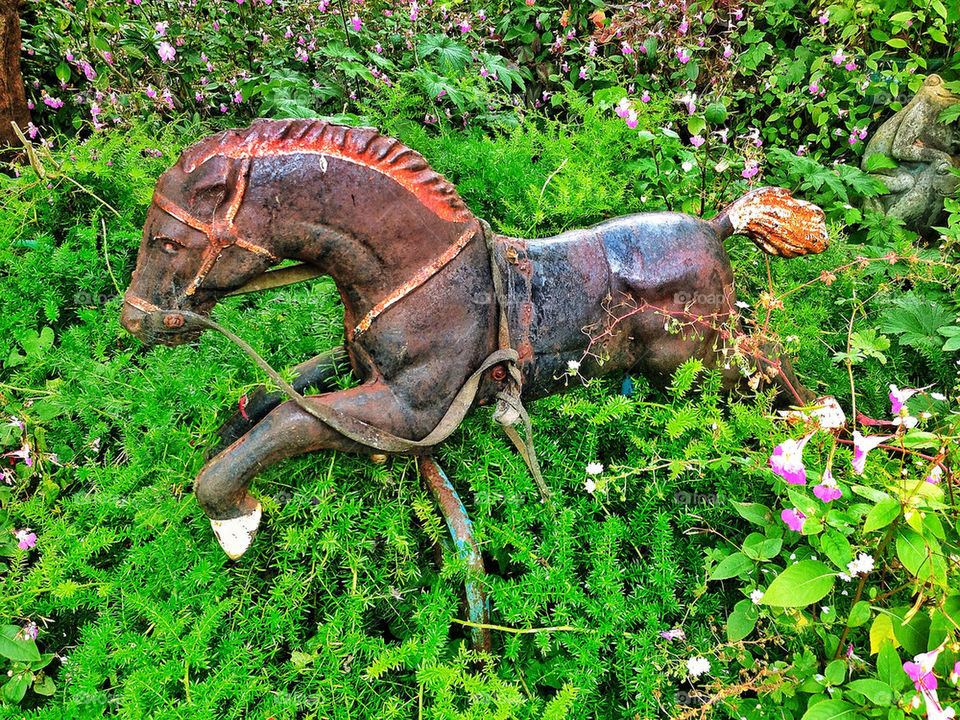 Rusty rocking horse in a garden