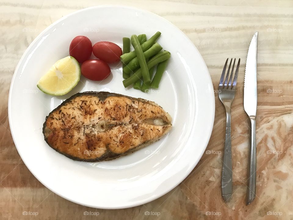 Healthy pan fried salmon fish with steamed vegetables