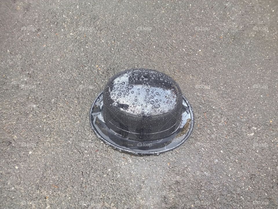 Plastic bowler hat wet by rain water.