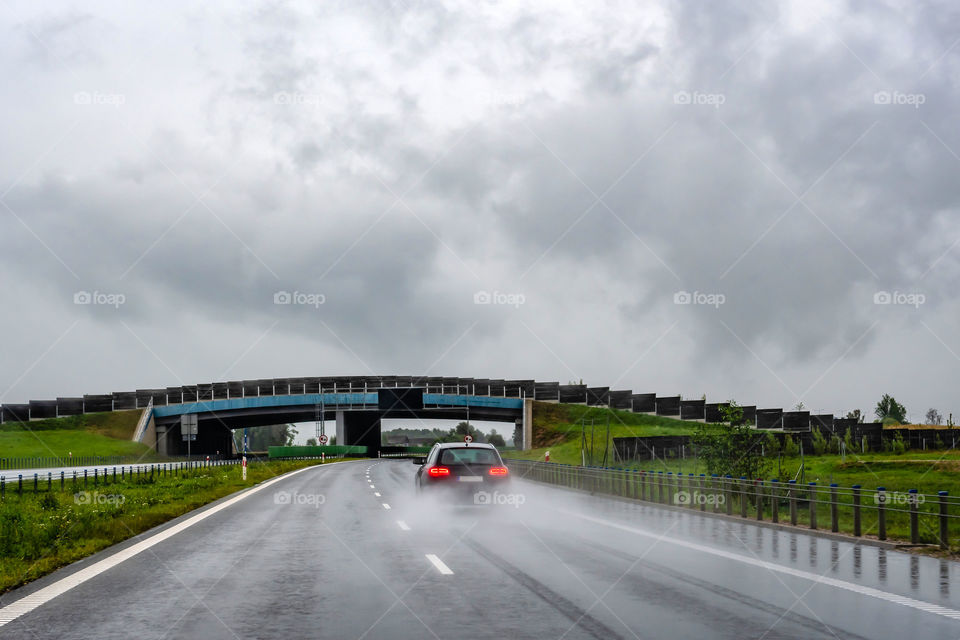A car on wet road in the rain. View from the rear through the car window.