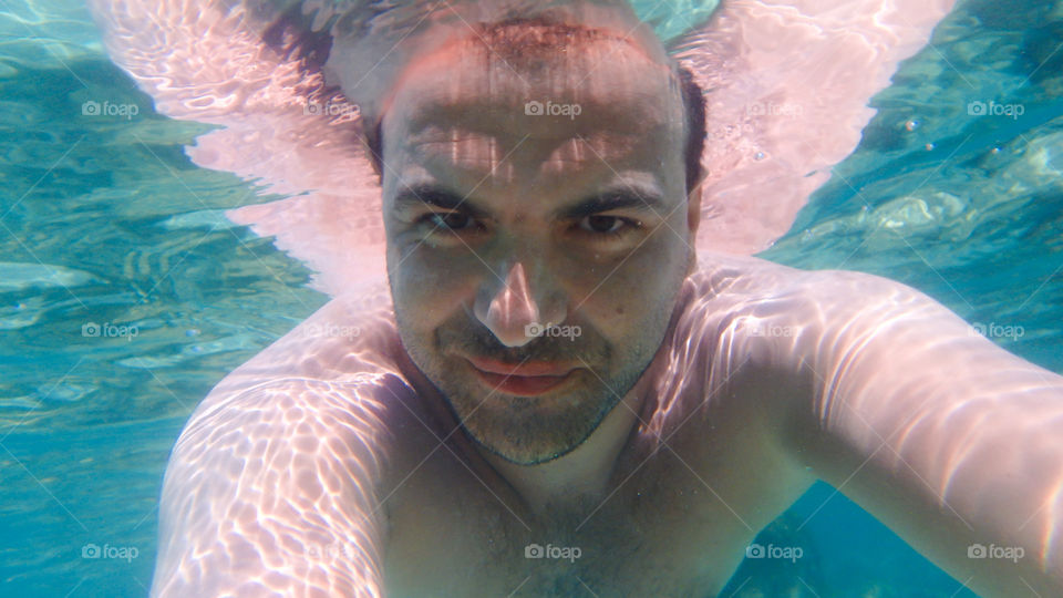 man underwater photographing himself