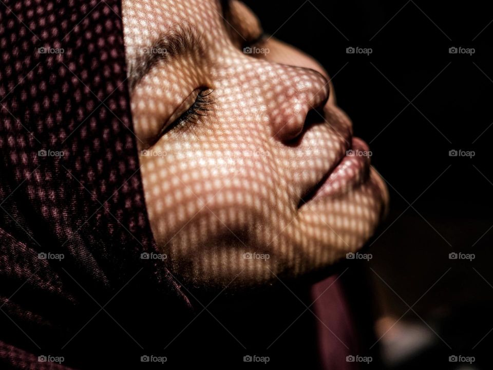 Sun net creating shadows on a lady smiling face