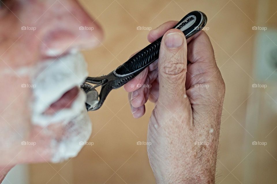 Man shaving his beard in the bathroom