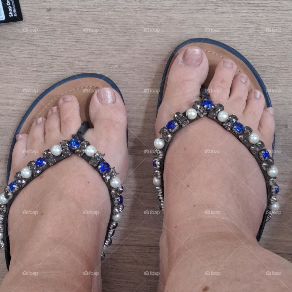 ladies feet in blue flipflops,painted toenails neat
