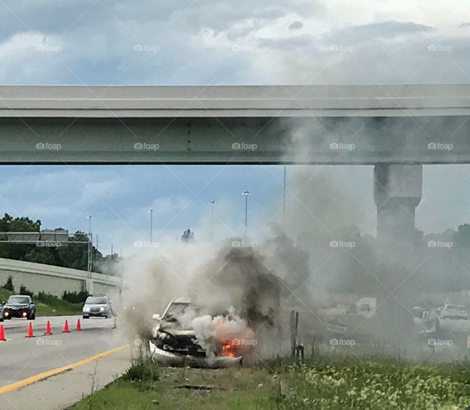 Car on fire on the side of the road 