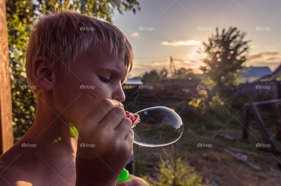 Boy making big soap bubble