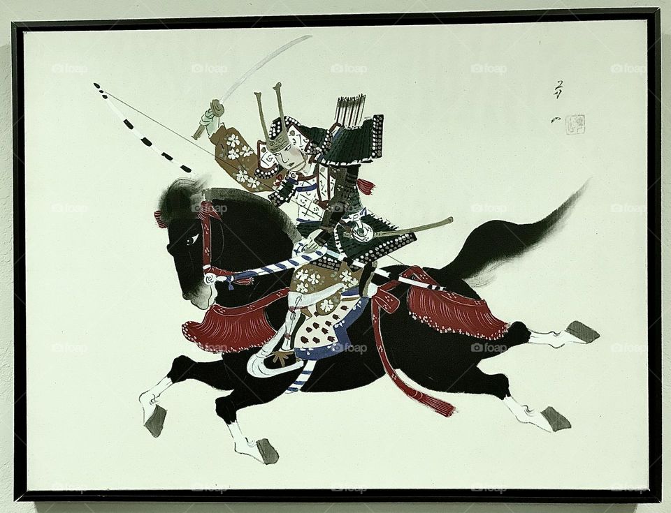 A period artwork depicting a female samurai riding into action.