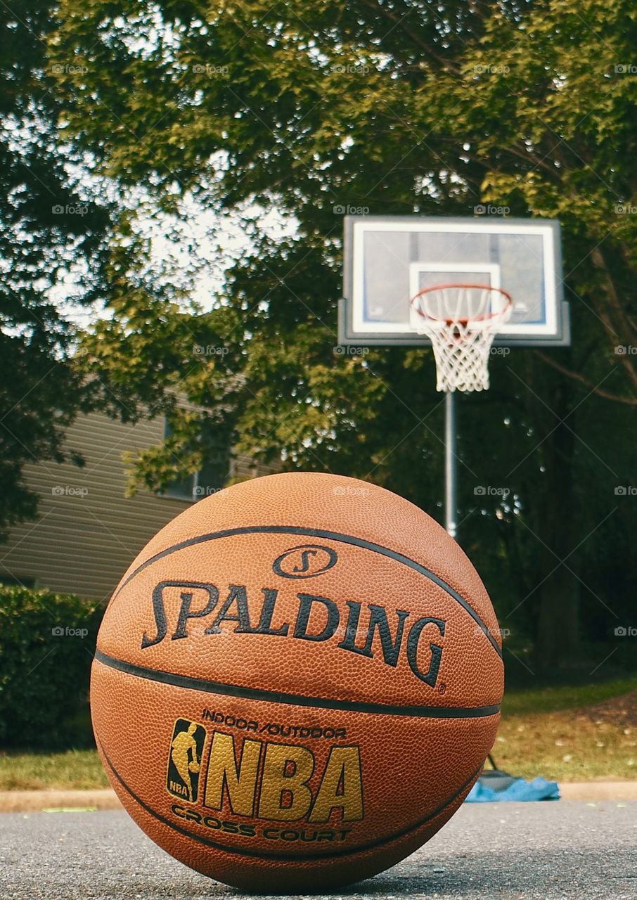 Basketball and bent hoop after shooting some hoops. 