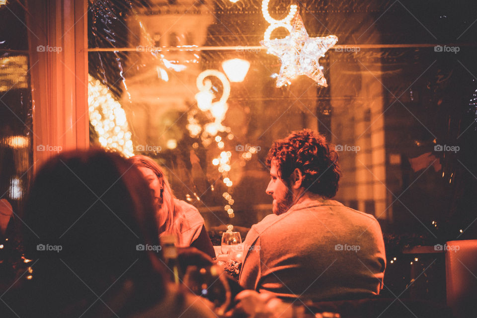 Group Of Friends Enjoying Christmas Drinks At Night Out Bar Restaurant
