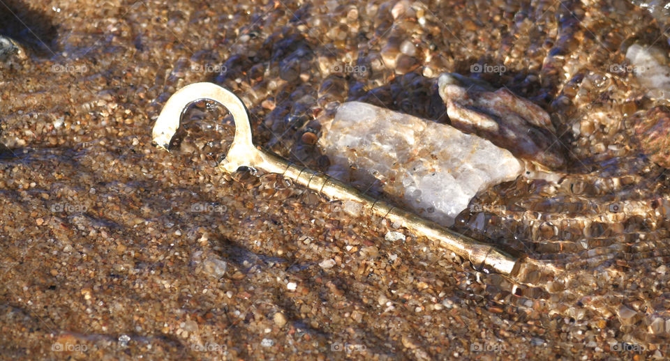 Old Brass Key In Sand And Water