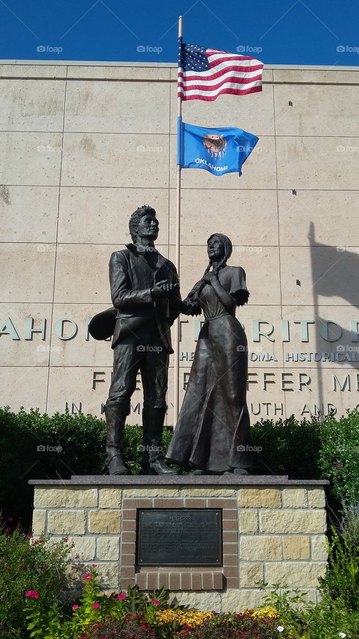 this sculpture captures the first Indian / American marriage in oklahoma in front of the first oklahoma state capital.