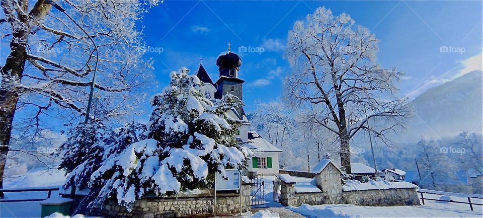 This is a winter wonderland with snow covered trees and a church in “Kochel am See”, “Kochel at the Lake”, a small pre Alpine township known for its hot geyser springs and saunas. 2024. Hypnotic Productions