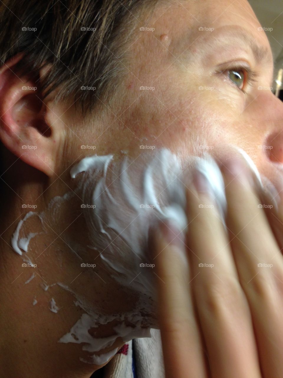 Man applying shaving cream in preparation of his daily shaving routine.