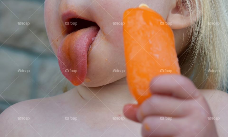 Eating orange popsicle 