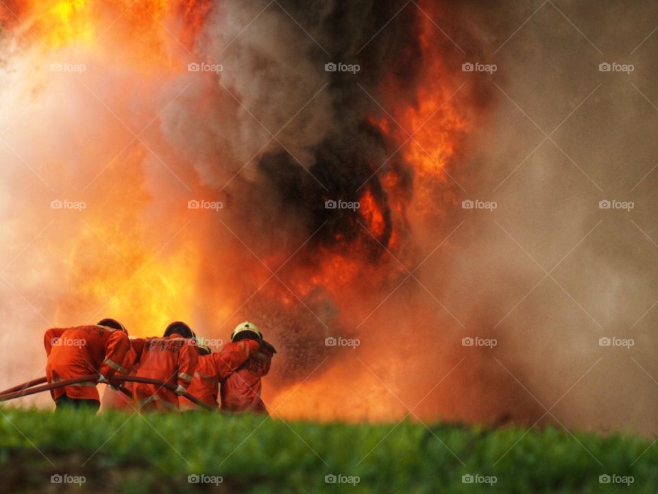 Rear view of firefighters extinguishing fire