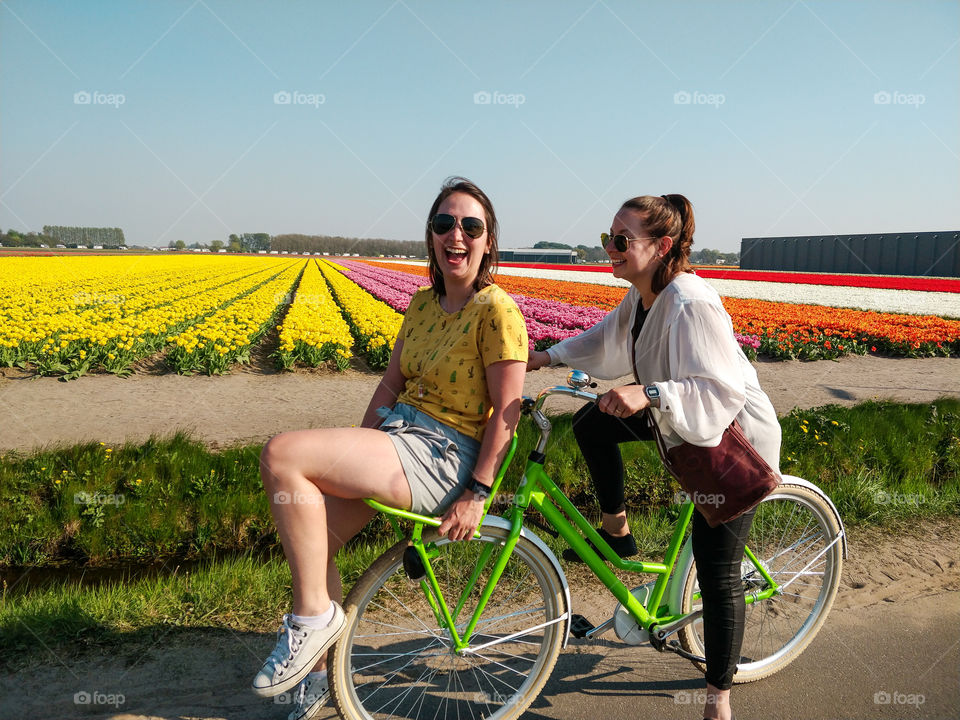 Girls riding a bike with tulip fields in the background