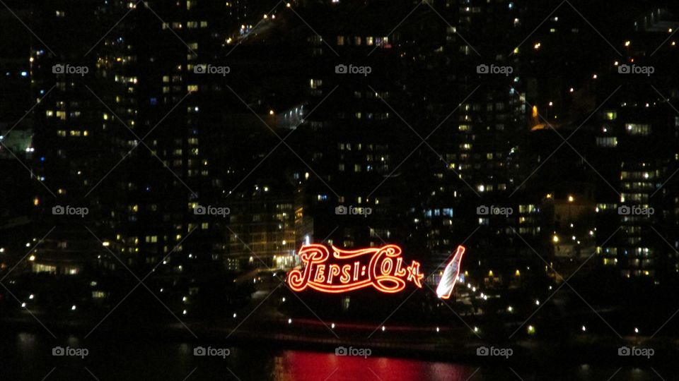 “Pepsi Cola” Lighted Sign on Top of a City Skyscraper at Night 