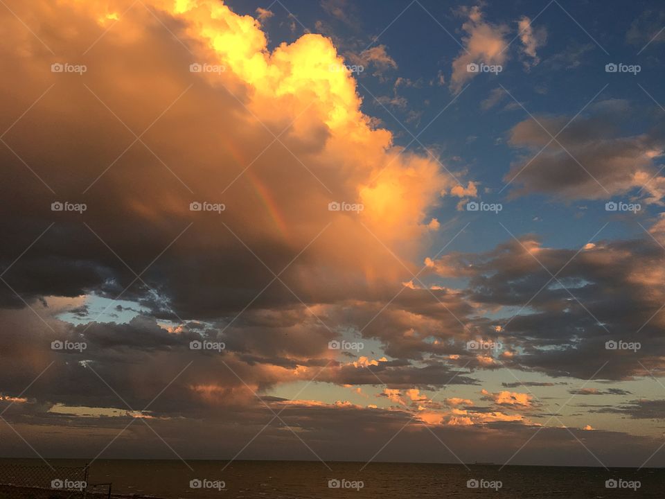 Rainbow through a storm cloud during a spectacular sunset