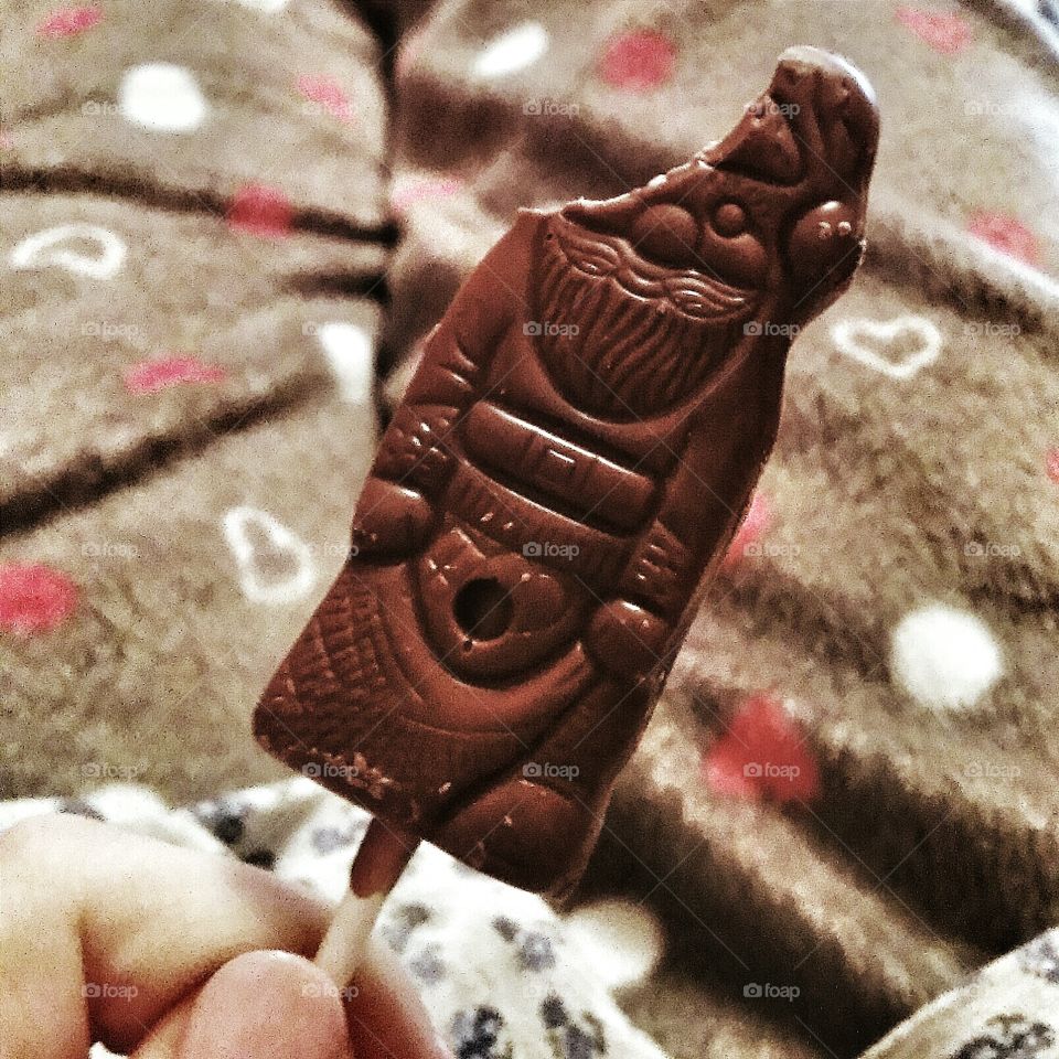 Santa Claus shaped chocolate lollipop with bite missing