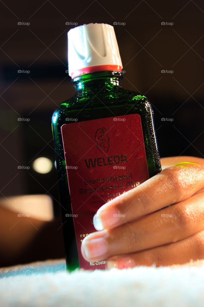 A weleda bottle of oil in a hand