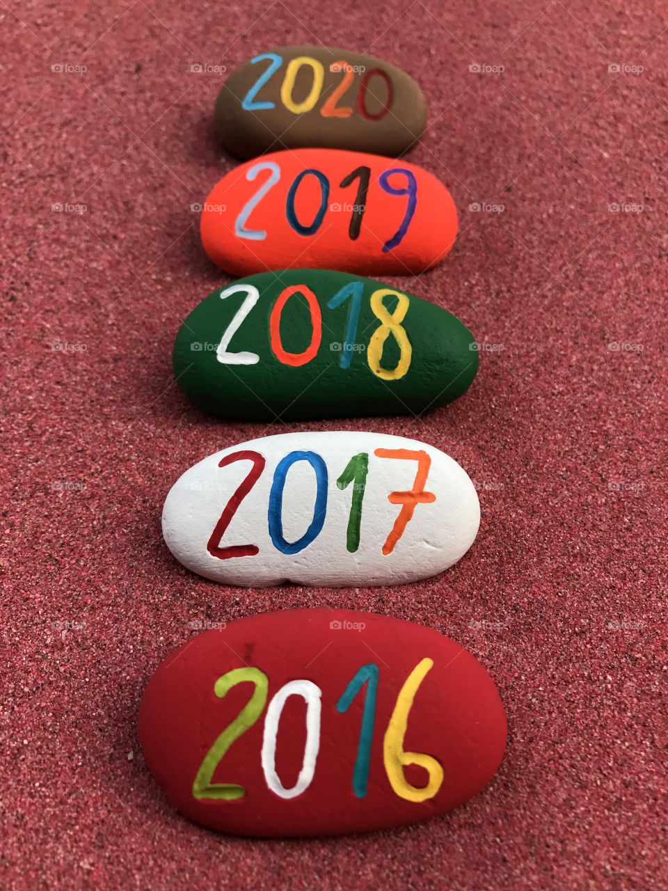 2016,2017,2018,2019,2020 on painted stones over red sand