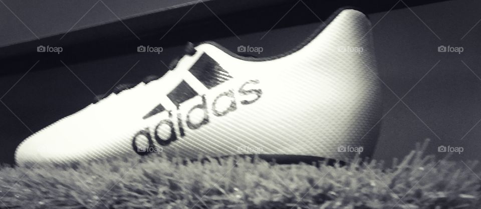 a close-up look of a Adidas studs on the grass