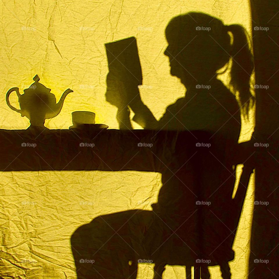 Silhouette of a girl reading 