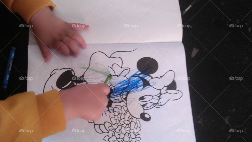 A child s hand colors pictures.