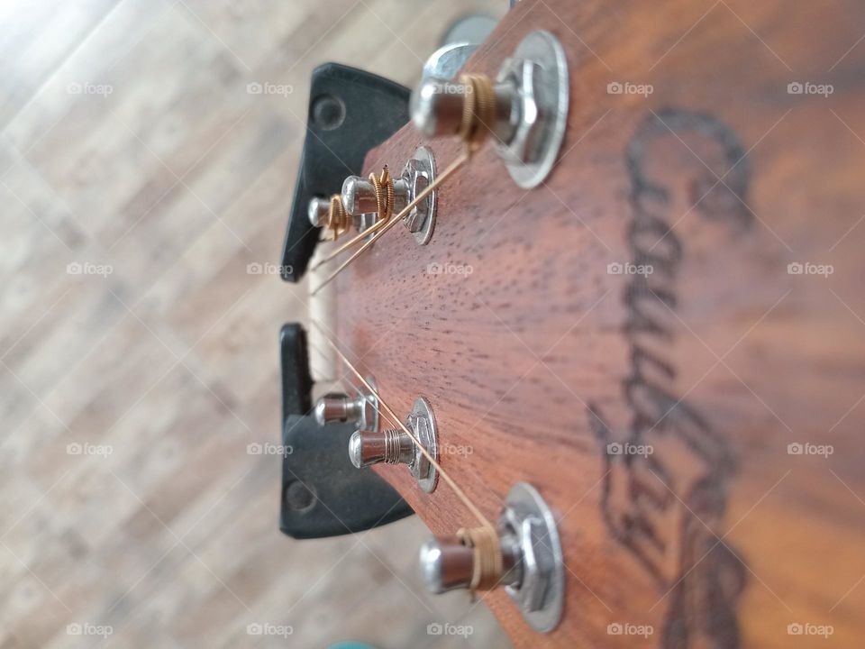 An acoustic guitar is a type of guitar where the sound produced comes from the vibration of the guitar strings that are channeled through the saddle and bridge where the strings are attached into the sound chamber