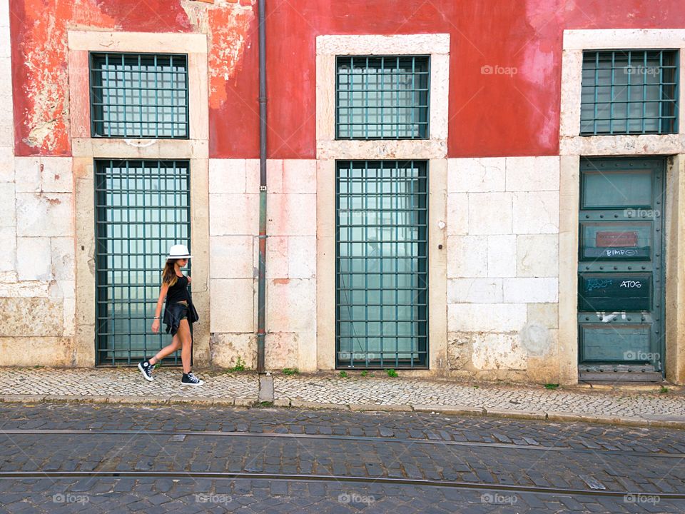 Young stylish woman walking on sidewalk