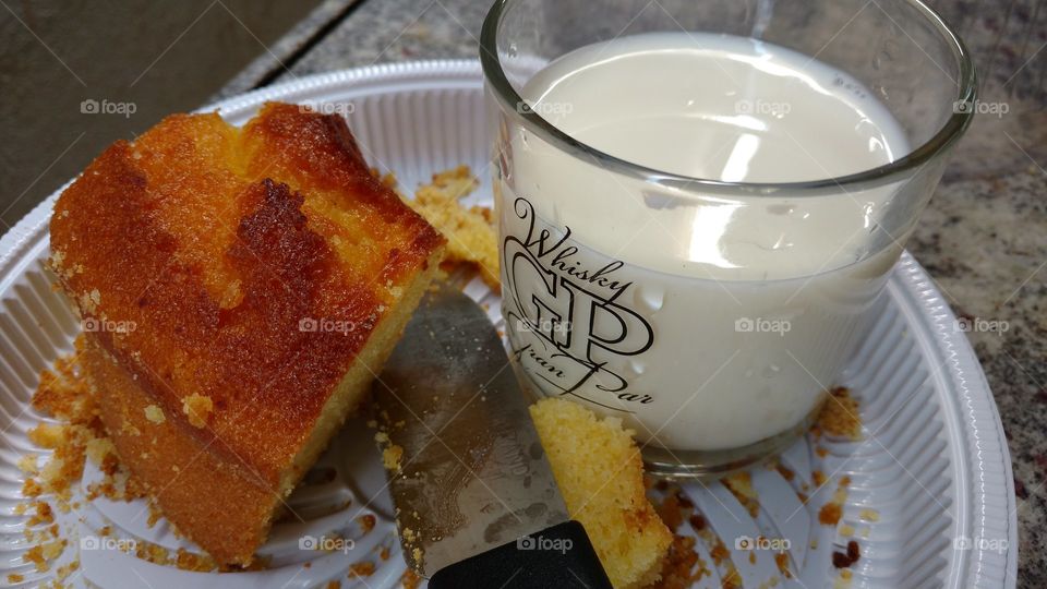 Um pedaço de bolo e um copo de leite.