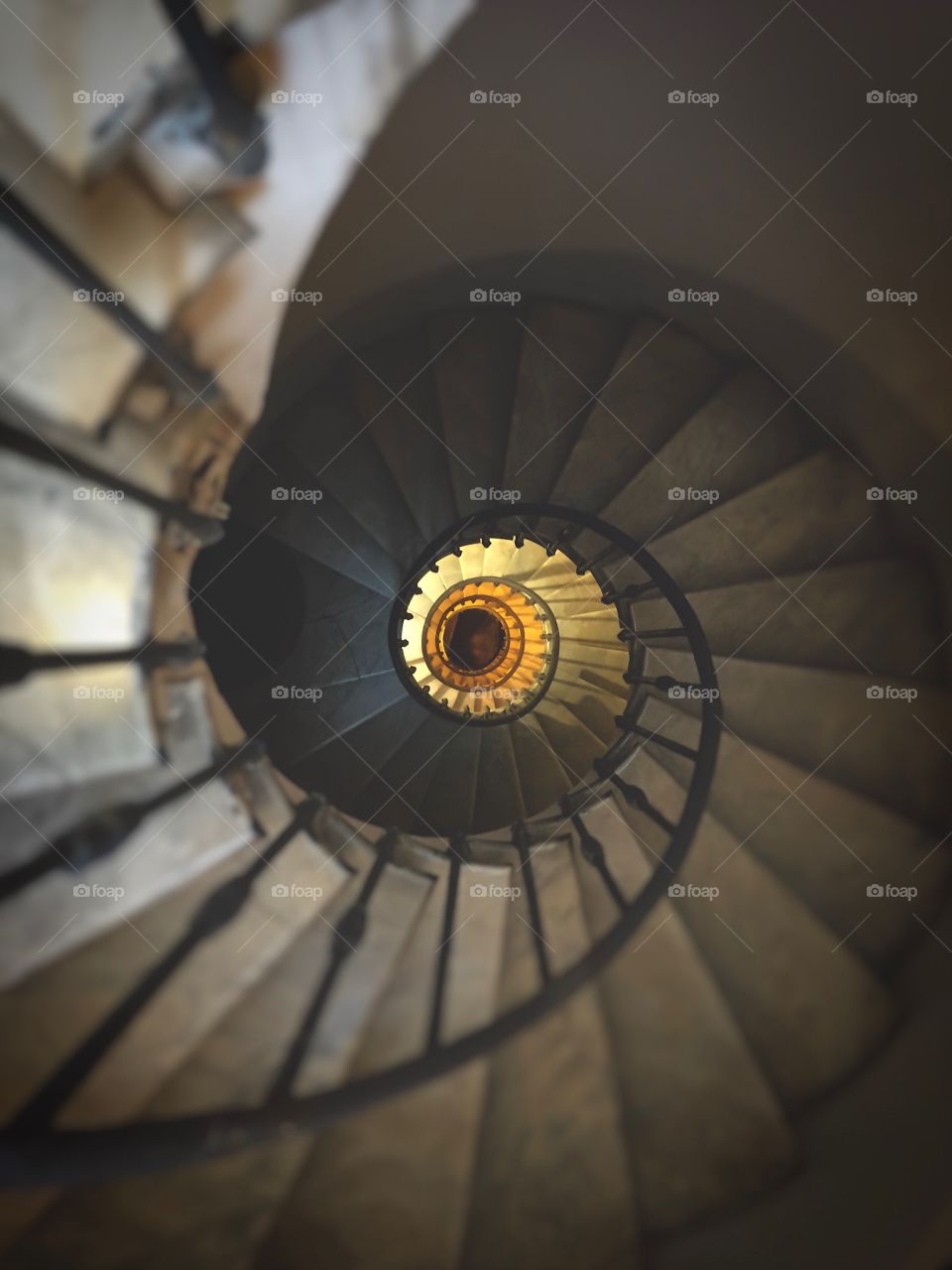 ancient spiral staircase with wrought iron handrail and marble steps