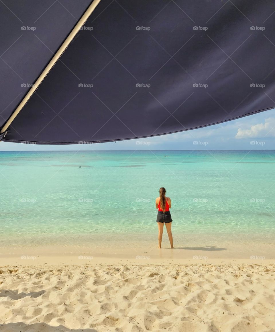 desde la sombrilla veo a la muchacha en la playa