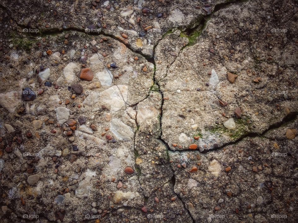 Rock cracks and grass in the concrete close up