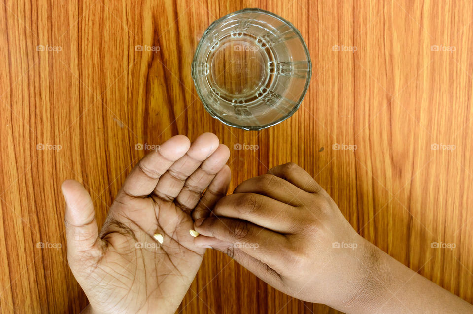Self-treatment at home as per prescribed by doctor. Close up of a man pouring medicine into his hand. Medical, health care or people concept. Side Angel view. Close up with copy space room for text.