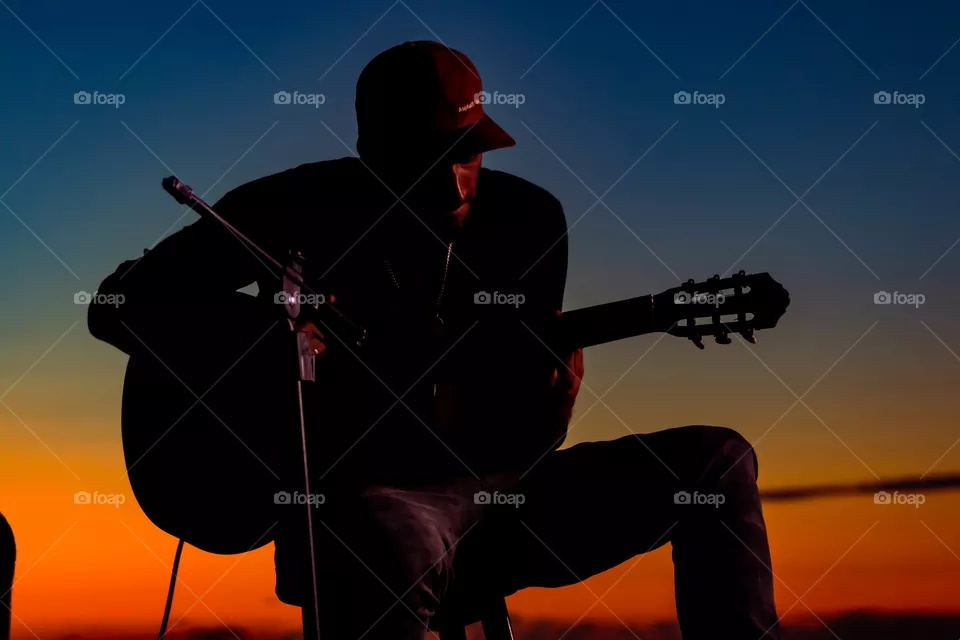Silhueta de música tocando violão.