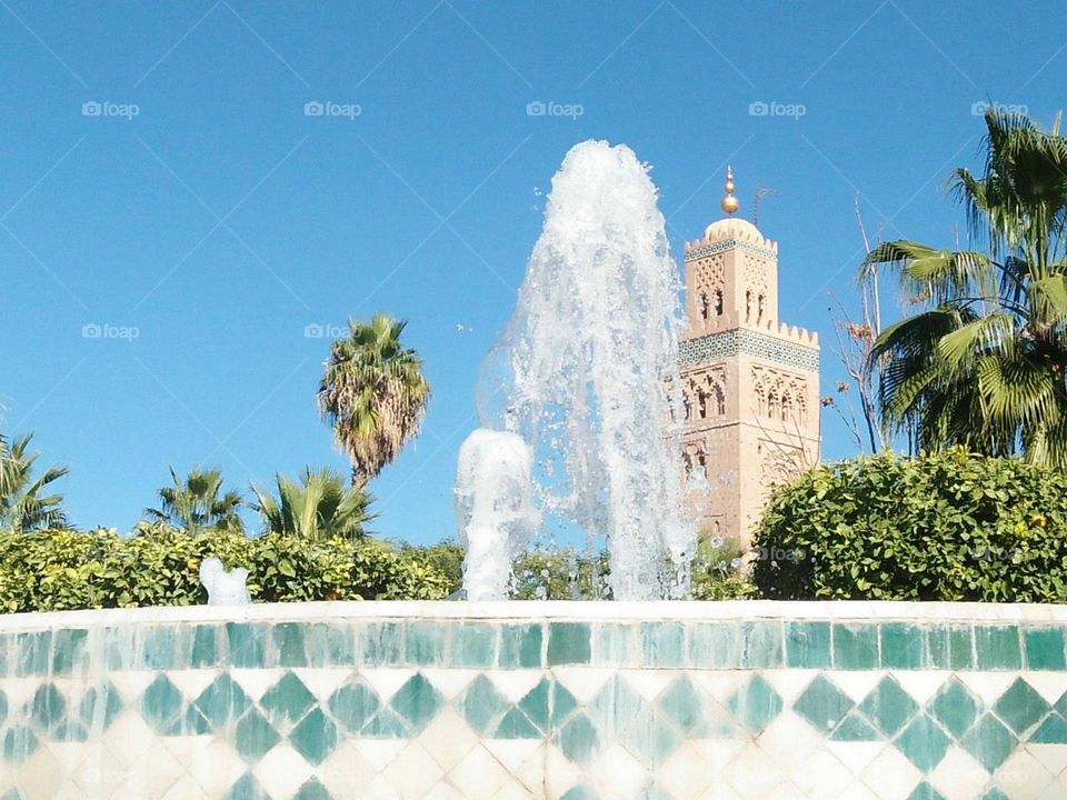 Beautiful fountain  and view to Kotoubia tower mosque at marrakech city in Morocco.