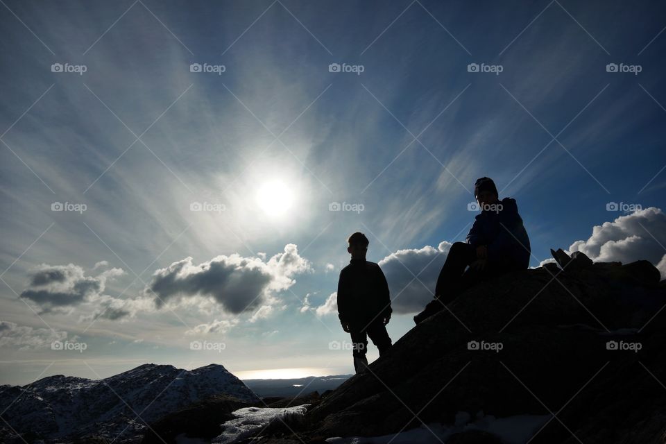 Silhouette of brothers on rock